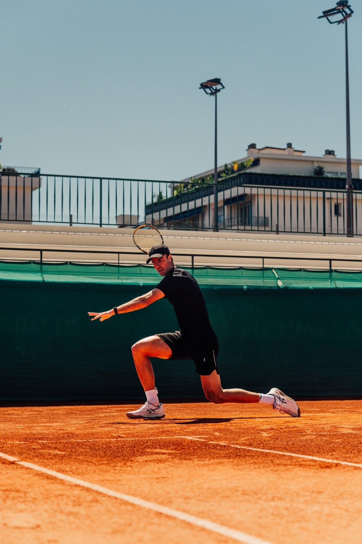 Joueur de tennis en train d'exécuter une seconde balle de service avec effet kick, le corps en extension et la raquette brossant la balle.