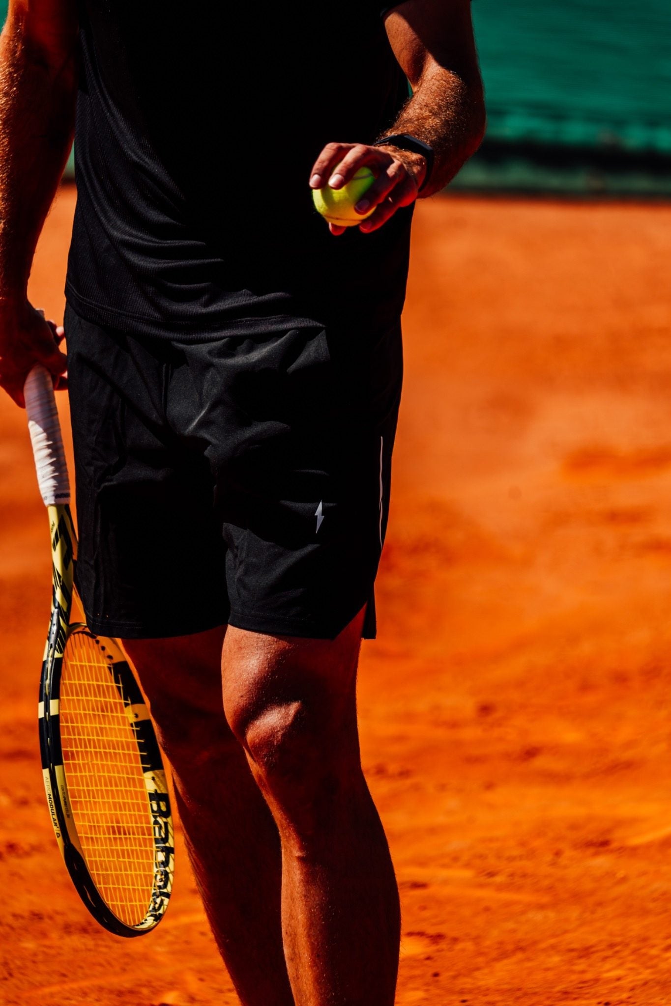 Vue aérienne d'un match de tennis en simple sur terre battue, illustrant un schéma tactique avec un joueur au filet et l'autre en fond de court.